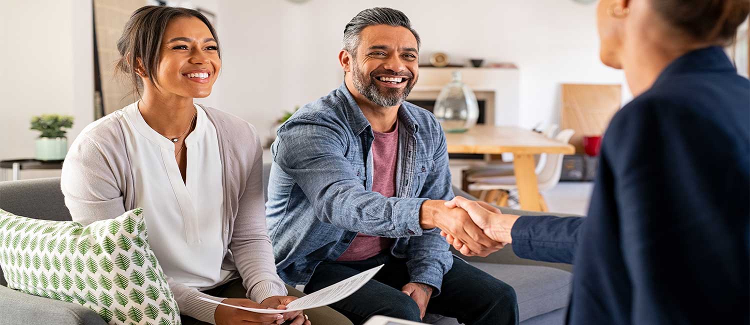 Couple shakes hands with insurance agent