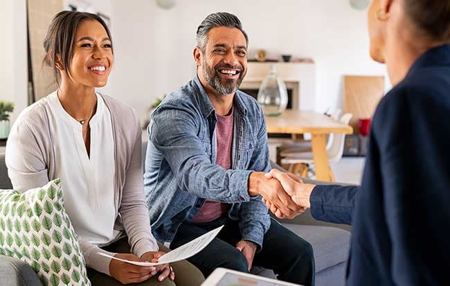 Couple shakes hands with insurance agent